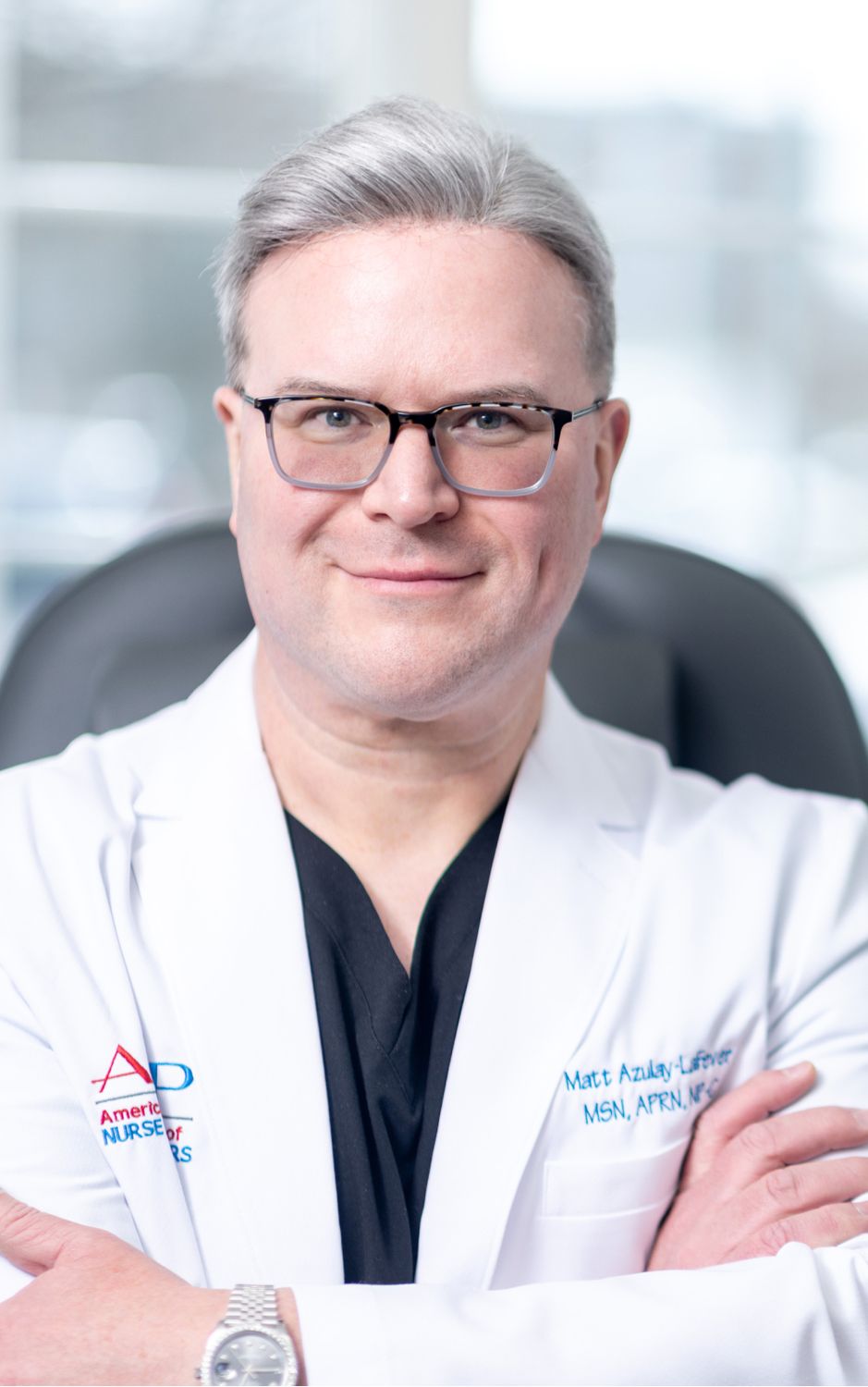 Matt Azulay-LaFever, MSN, APRN, NP-C, in white coat, smiling confidently.