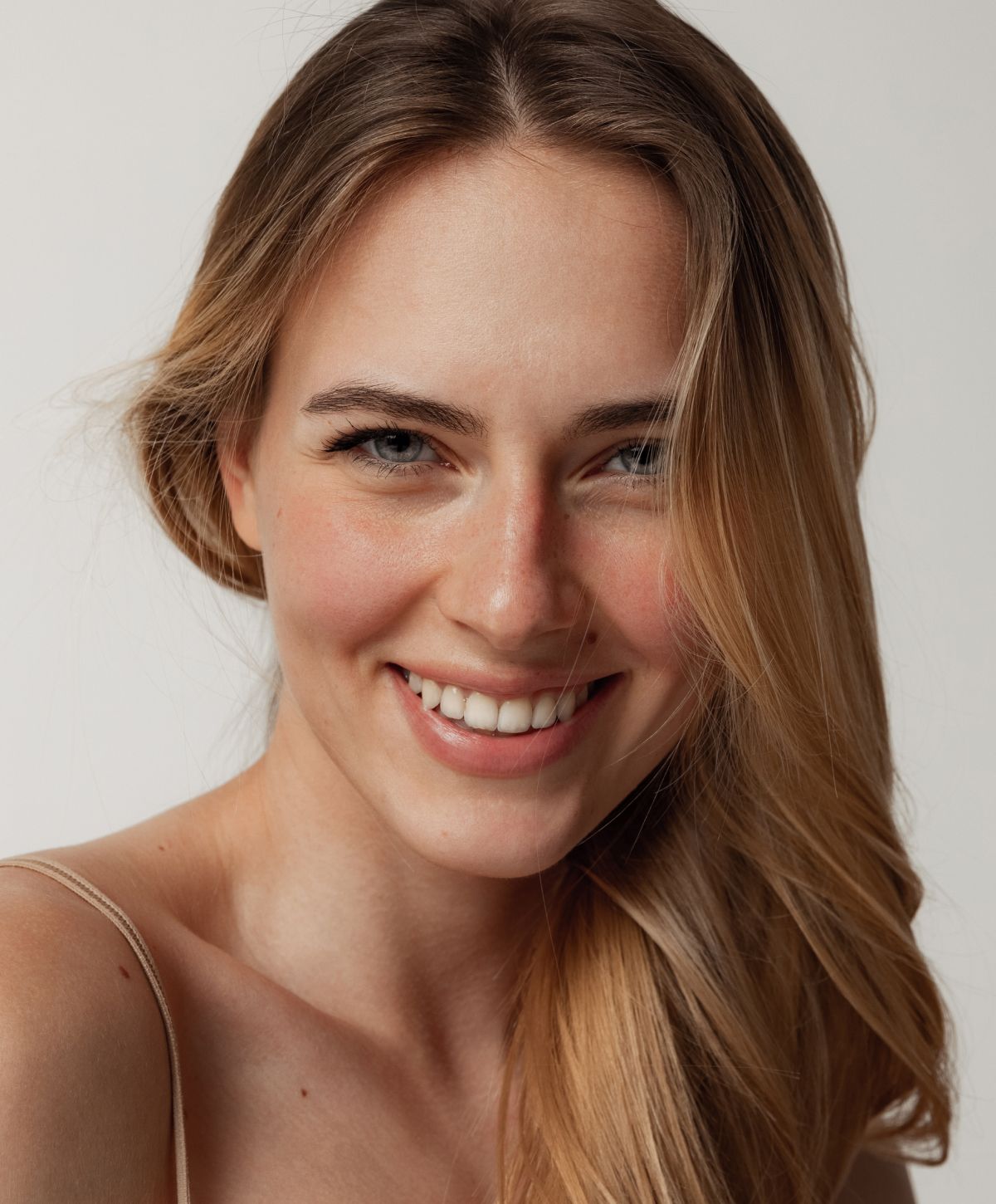 Smiling woman with long, wavy hair.